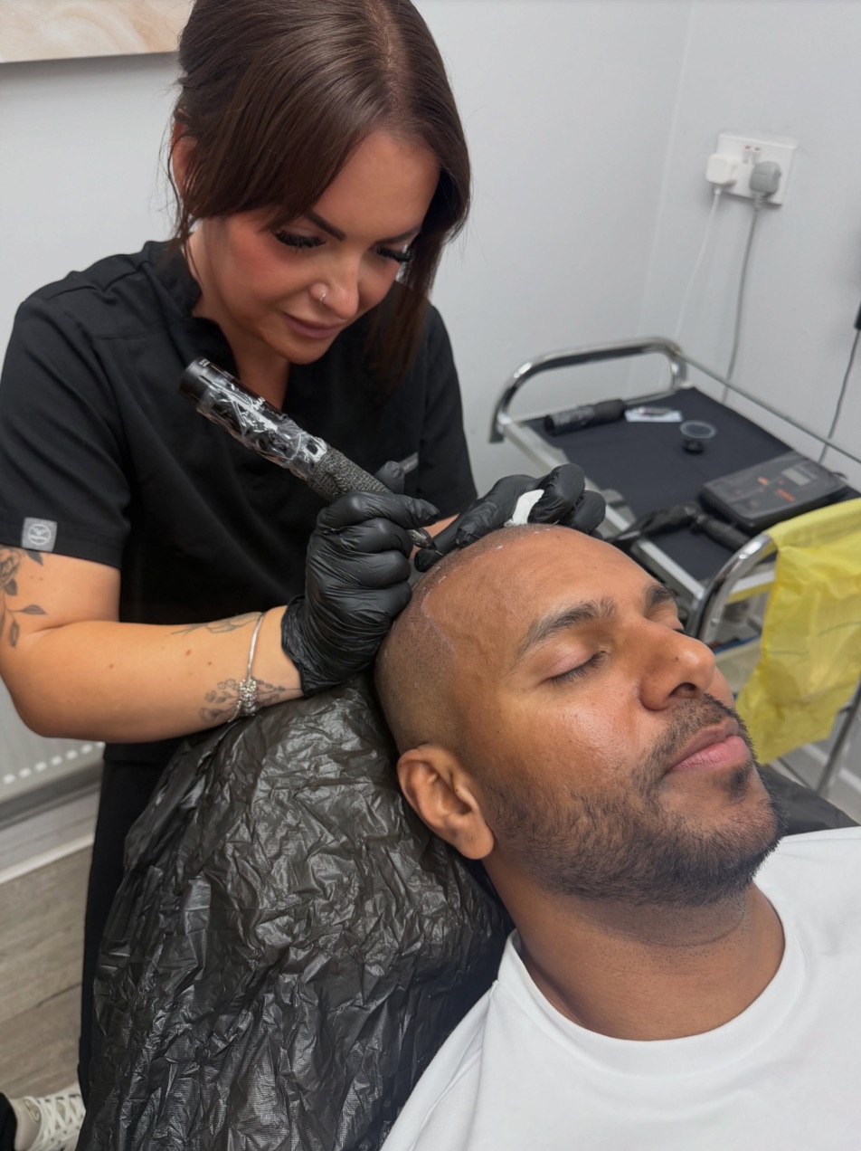 Libby Fuller, in gloves, placing scalp micropigmentation along a client's hairline